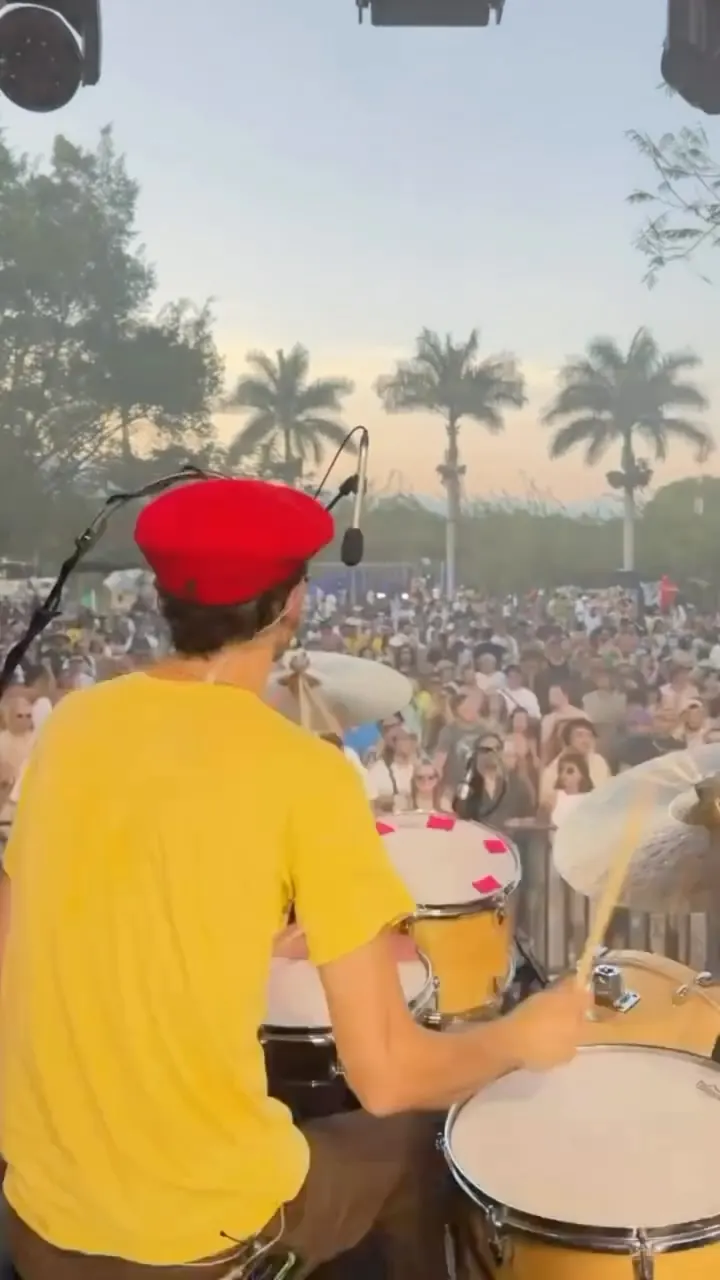 A drummer in a red beret playing to the lot at golden hour
