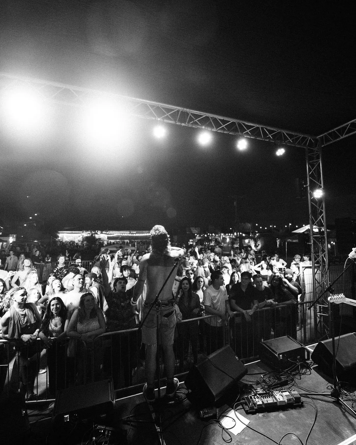 Stage lights over a huge crowd in black and white